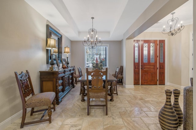 dining space featuring an inviting chandelier, baseboards, and a tray ceiling