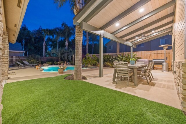 yard at twilight featuring a fenced in pool, a patio, outdoor dining area, and a fenced backyard