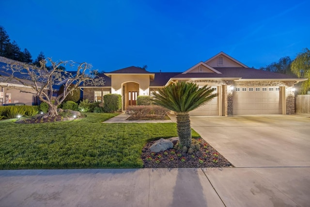 view of front of house with concrete driveway, an attached garage, a front yard, and stucco siding