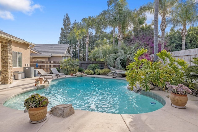 view of swimming pool with a patio area, central AC unit, a fenced backyard, and a fenced in pool