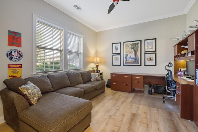 living area featuring visible vents, crown molding, a ceiling fan, and light wood-style floors