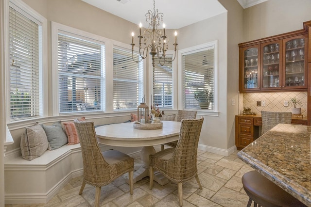 dining room with baseboards, a notable chandelier, and stone tile floors