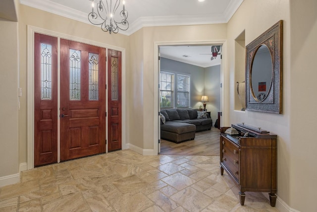 foyer featuring an inviting chandelier, ornamental molding, baseboards, and stone tile flooring