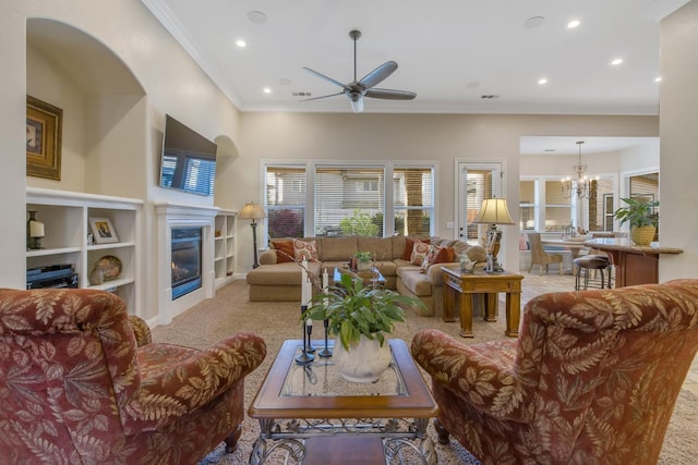 living area featuring recessed lighting, a glass covered fireplace, crown molding, ceiling fan with notable chandelier, and light colored carpet