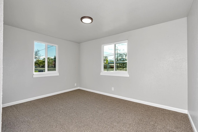 spare room with baseboards and carpet