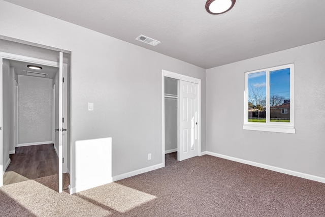 unfurnished bedroom with a closet, visible vents, baseboards, and carpet