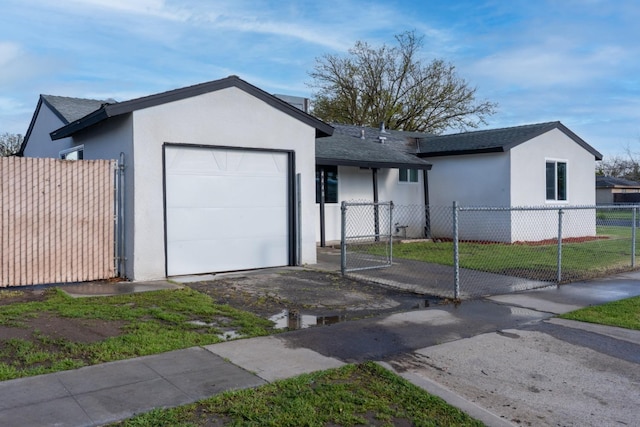 single story home featuring a gate, a garage, a fenced front yard, and stucco siding