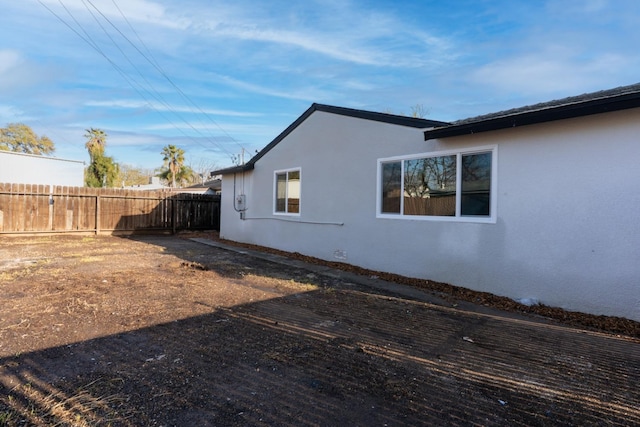 view of property exterior featuring stucco siding and fence