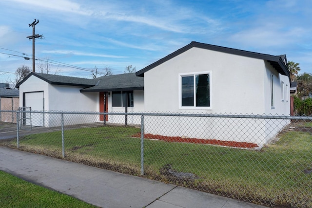 view of front of home with a front lawn, a fenced front yard, and stucco siding