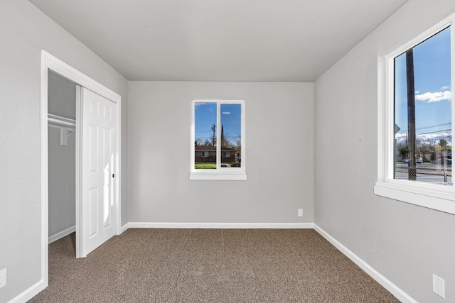 unfurnished bedroom featuring a closet, baseboards, and carpet