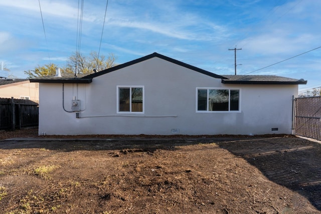 view of home's exterior featuring crawl space, fence, and stucco siding