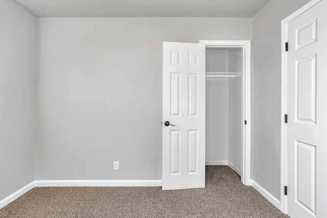 unfurnished bedroom featuring a closet, baseboards, and carpet floors