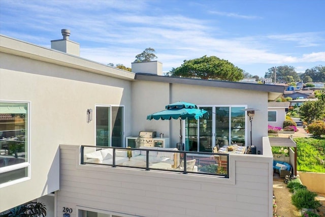 back of property featuring stucco siding and a chimney