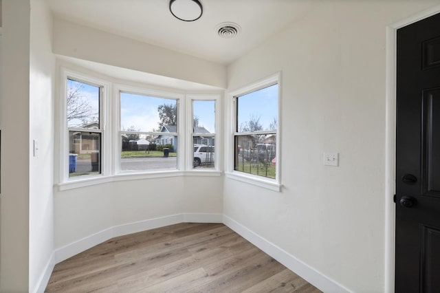 spare room with plenty of natural light, baseboards, visible vents, and light wood-type flooring