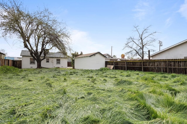 view of yard featuring an outdoor structure and fence