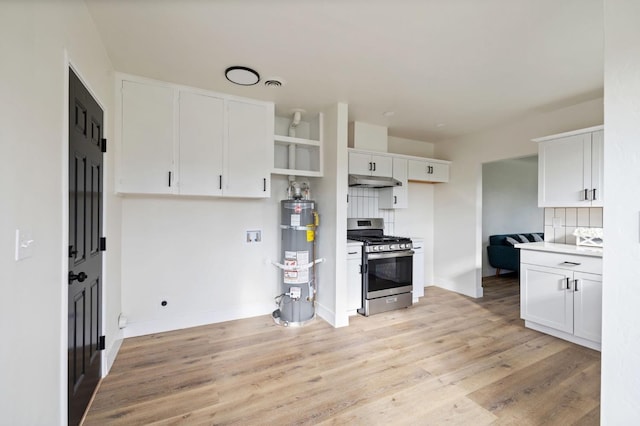 kitchen featuring under cabinet range hood, open shelves, white cabinets, secured water heater, and stainless steel range with gas stovetop