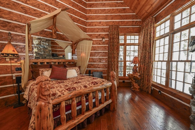bedroom featuring multiple windows, hardwood / wood-style floors, and vaulted ceiling