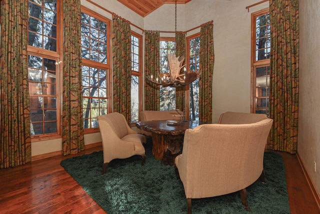 sitting room featuring baseboards, wood-type flooring, and high vaulted ceiling
