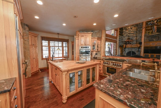 kitchen featuring dark wood-style floors, wooden counters, a sink, high end stainless steel range, and a center island