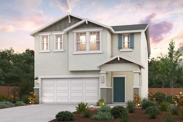 view of front of property featuring a garage, stucco siding, driveway, and fence