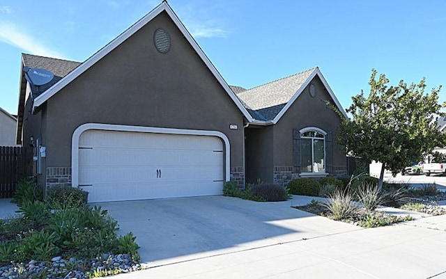 view of front facade with a shingled roof, concrete driveway, stucco siding, a garage, and stone siding