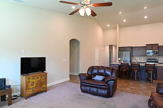 living area featuring carpet flooring, recessed lighting, arched walkways, and ceiling fan