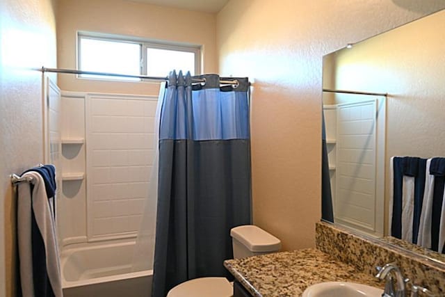 bathroom with shower / bath combo with shower curtain, toilet, and vanity