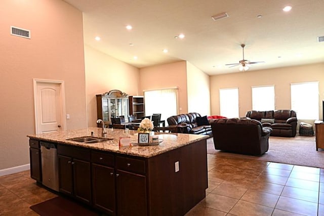 kitchen featuring visible vents, a ceiling fan, a sink, stainless steel dishwasher, and open floor plan