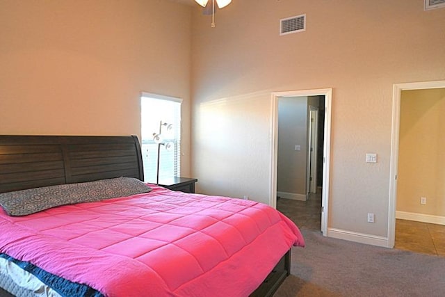 bedroom featuring a high ceiling, carpet flooring, visible vents, and baseboards