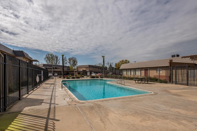 community pool featuring a patio and fence