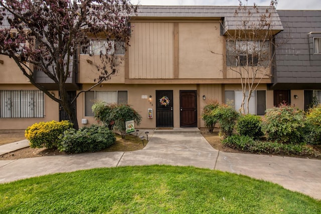 townhome / multi-family property featuring mansard roof