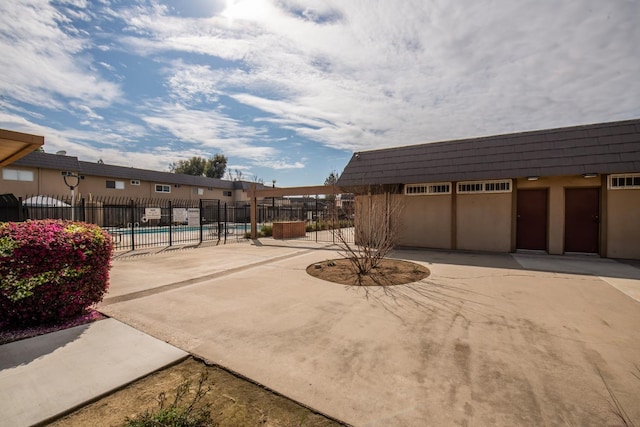 exterior space with a community pool and fence