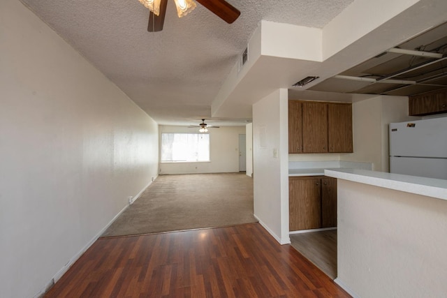 interior space featuring visible vents, baseboards, dark wood finished floors, dark carpet, and a textured ceiling