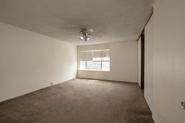 carpeted empty room with a textured ceiling and a ceiling fan