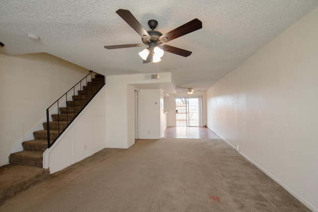 unfurnished living room with visible vents, light colored carpet, a textured ceiling, and a ceiling fan