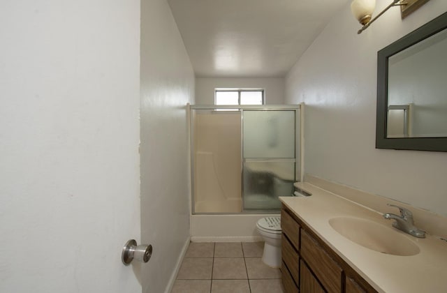 bathroom with vanity, baseboards, shower / bath combination with glass door, tile patterned floors, and toilet