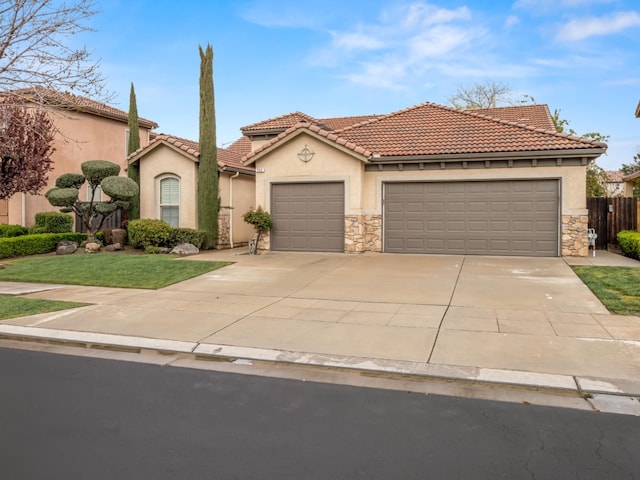 mediterranean / spanish-style home featuring stucco siding, driveway, a tile roof, stone siding, and a garage