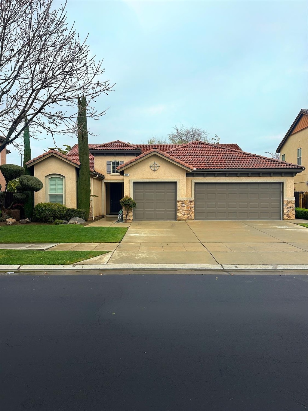 mediterranean / spanish home featuring stucco siding, a garage, concrete driveway, and a tile roof