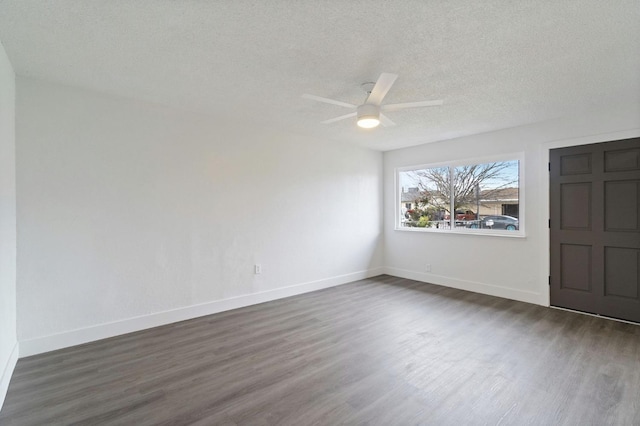 unfurnished room with baseboards, dark wood-type flooring, and a textured ceiling