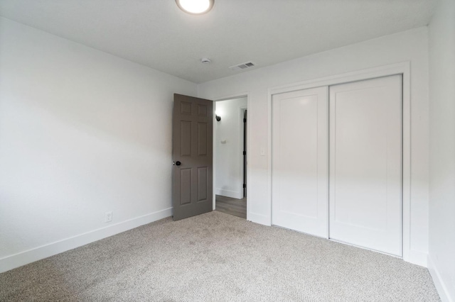 unfurnished bedroom with visible vents, baseboards, carpet, and a closet