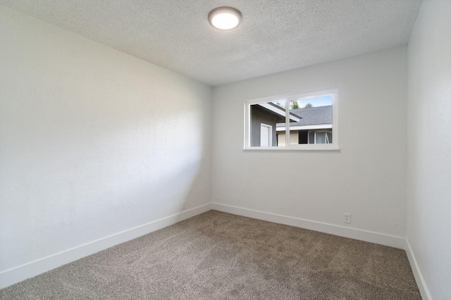 carpeted empty room featuring baseboards and a textured ceiling