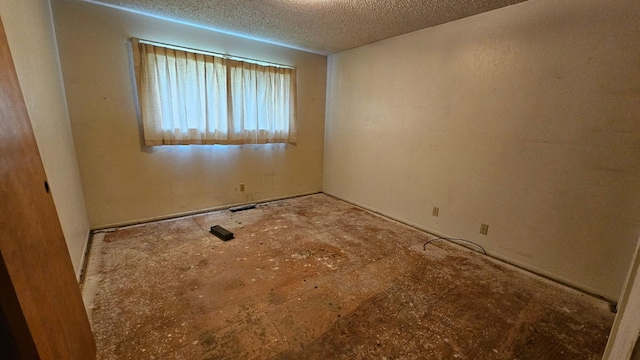 unfurnished room with a textured ceiling