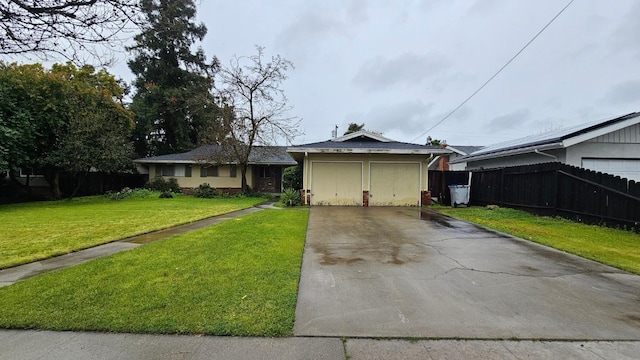 view of front of property with fence, a front yard, stucco siding, a garage, and driveway