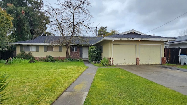 ranch-style home with stucco siding, concrete driveway, an attached garage, a front yard, and brick siding