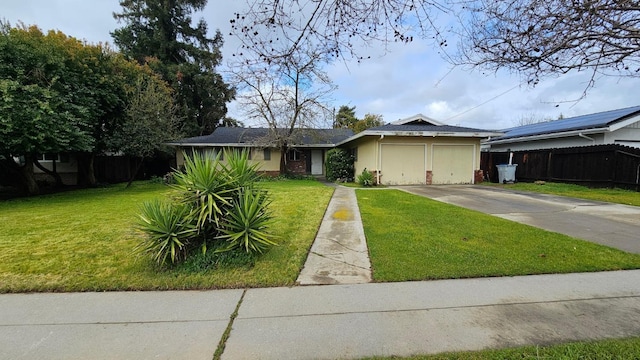 view of front of property with concrete driveway, a garage, fence, and a front lawn