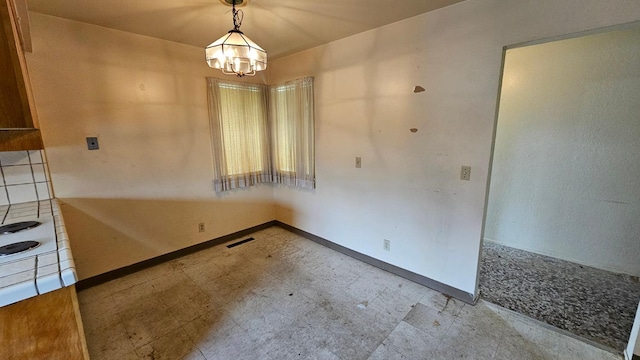 unfurnished dining area featuring tile patterned floors, visible vents, baseboards, and an inviting chandelier