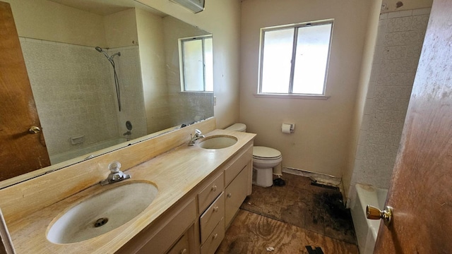 bathroom featuring walk in shower, toilet, double vanity, and a sink