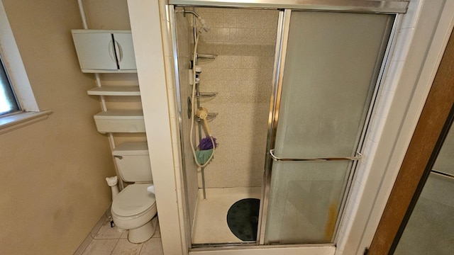 full bath with tile patterned floors, toilet, and a stall shower