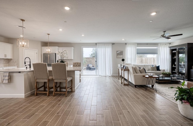 interior space featuring light wood finished floors, a breakfast bar area, light countertops, and freestanding refrigerator