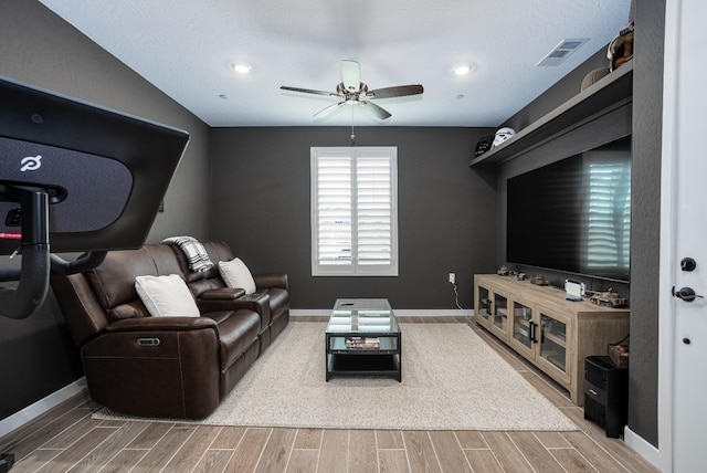 living area with ceiling fan, baseboards, visible vents, and wood finish floors